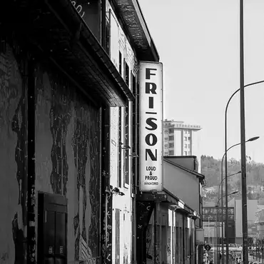 Photo en noir et blanc de la façade et le panneau Fri-Son