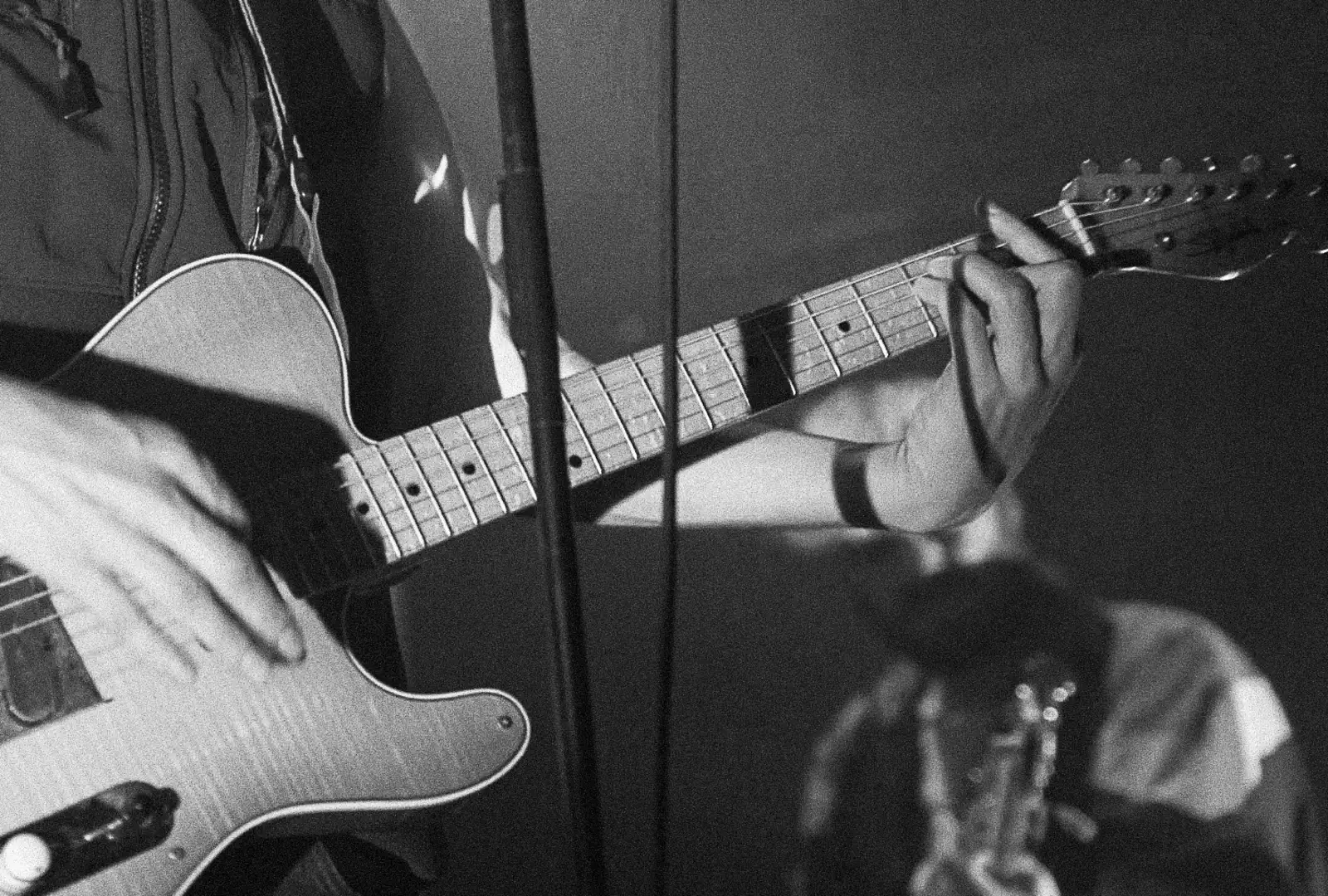 Photo en noir et blanc gros plan sur une guitare durant un concert