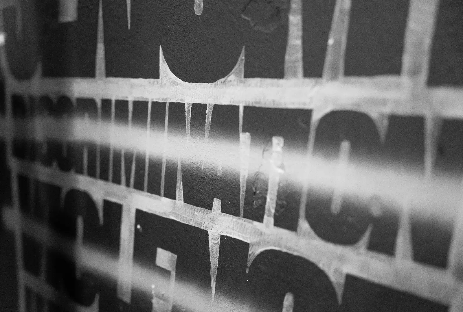 Photo en noir et blanc du mot Discrimination tracé sur un mur