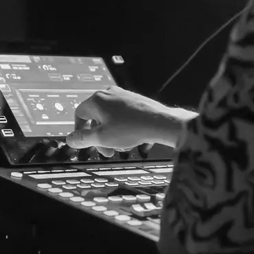 Photo en noir et blanc d'une main sur une console lumière