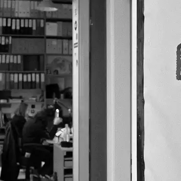 Photo en noir et blanc de la porte du bureau entrouverte