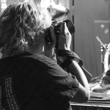 Photo en noir et blanc d'une photographe lors d'un concert