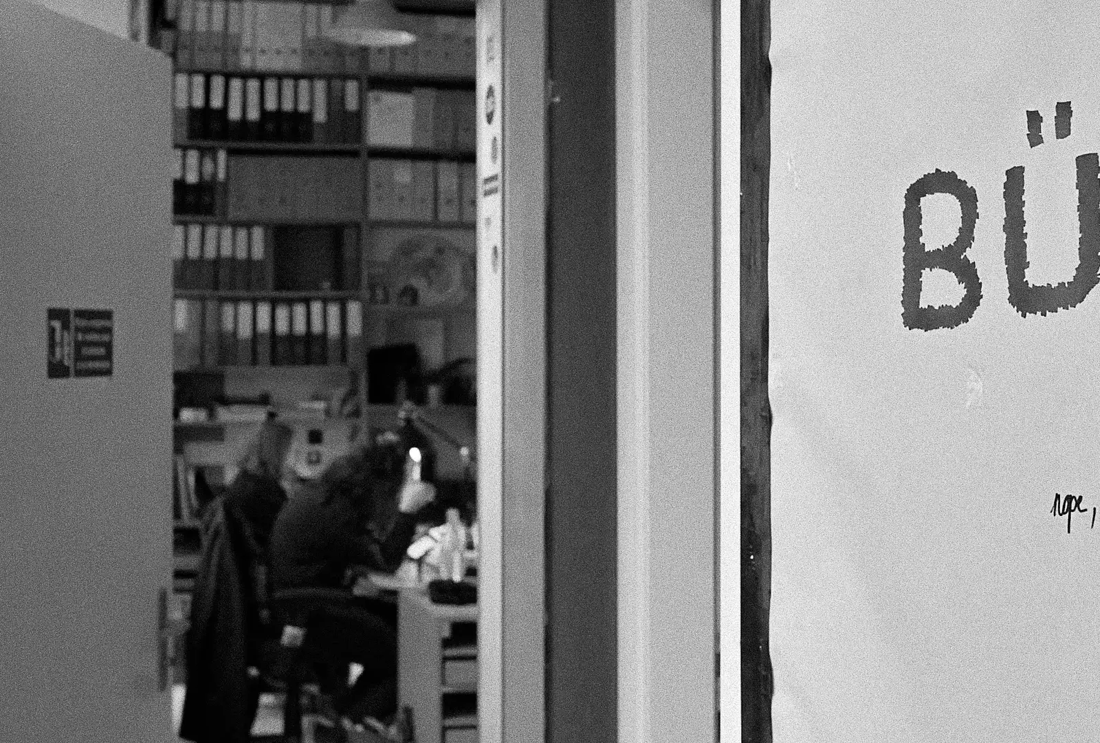 Photo en noir et blanc de la porte du bureau entrouverte